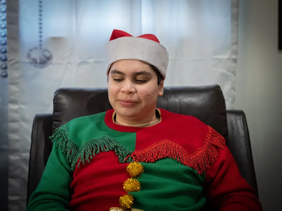 Caregiver in festive elf costume participating in holiday celebration activities
