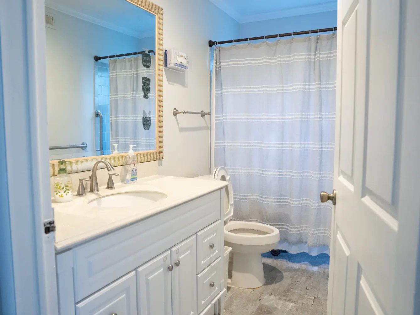 Accessible bathroom with white cabinetry, grab bars, and shower facilities