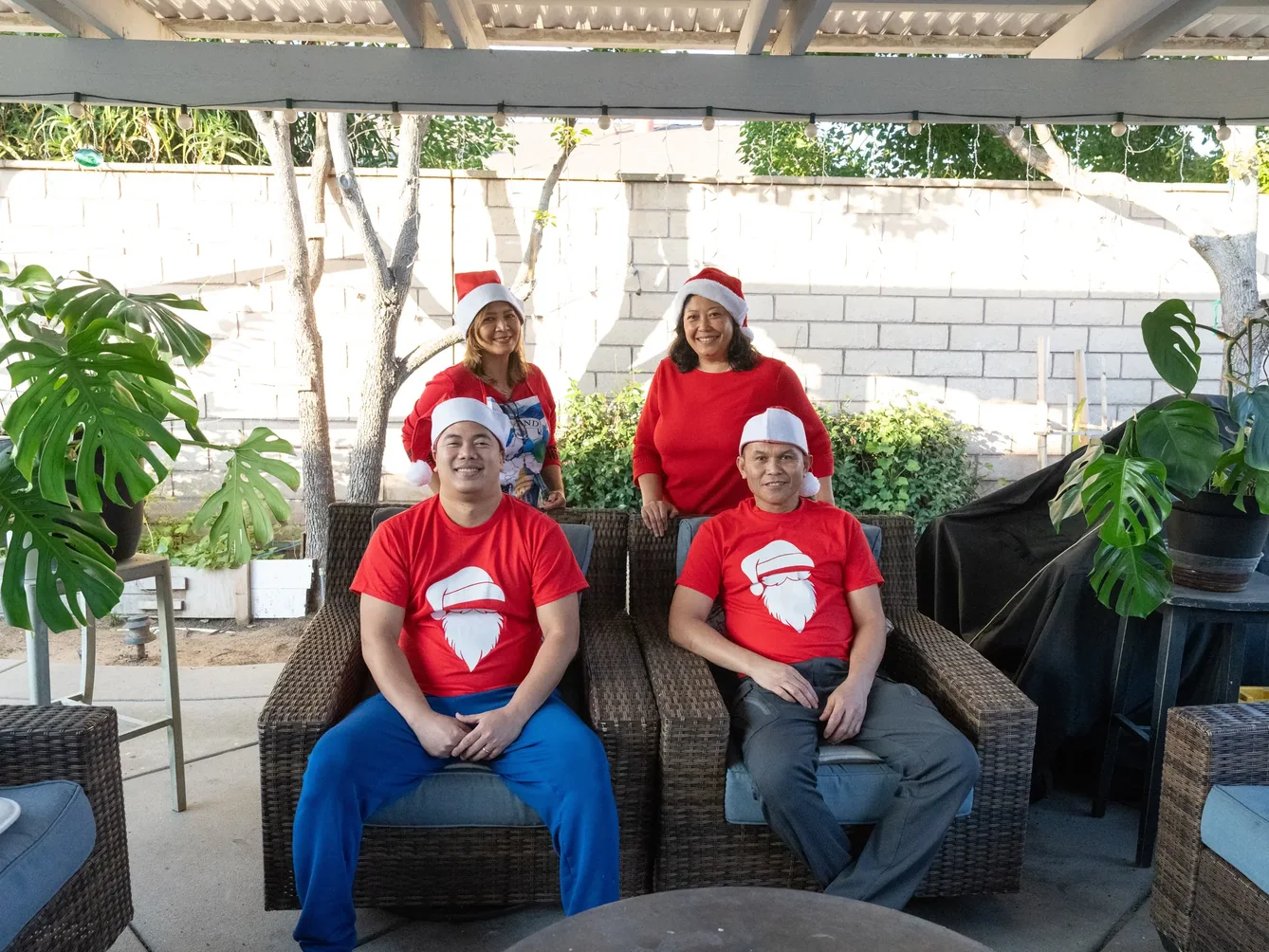 Staff members in festive red attire and Santa hats celebrating outdoors