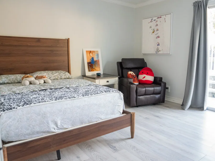 Comfortable resident bedroom with wooden bed and leather recliner